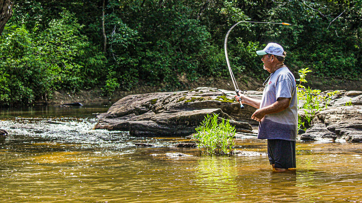 fisherman casting in a creek