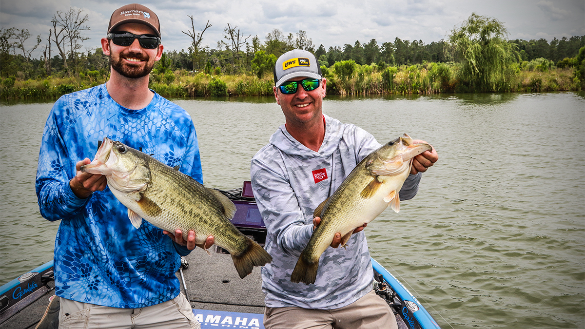 two fisherman holding big bass